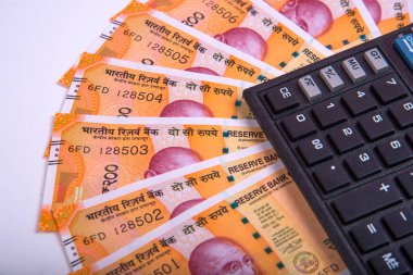 Beyaz arka planda Hint rupi faturaları ve hesap makinesi. Vergi ödeme konsepti veya yatırım çözümleri. Mali planlama ya da muhasebeci evrakları