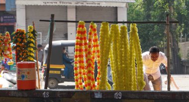 INDIA - 15 Ekim 2021: Hintli çiçek satıcıları ürünlerini gündüz vakti sokak çiçeği pazarında sunuyorlar