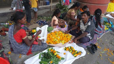 INDIA - 15 Ekim 2021: Hintli çiçek satıcıları ürünlerini gündüz vakti sokak çiçeği pazarında sunuyorlar