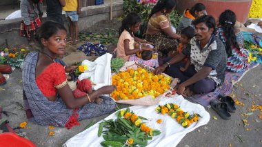 INDIA - 15 Ekim 2021: Hintli çiçek satıcıları ürünlerini gündüz vakti sokak çiçeği pazarında sunuyorlar