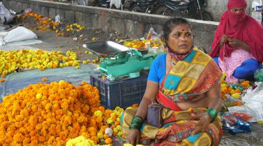 INDIA - 15 Ekim 2021: Hintli çiçek satıcıları ürünlerini gündüz vakti sokak çiçeği pazarında sunuyorlar