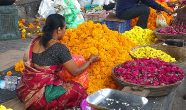 INDIA - 15 Ekim 2021: Hintli çiçek satıcıları ürünlerini gündüz vakti sokak çiçeği pazarında sunuyorlar
