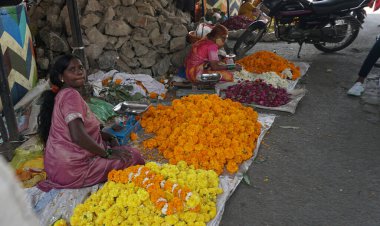 INDIA - 15 Ekim 2021: Hintli çiçek satıcıları ürünlerini gündüz vakti sokak çiçeği pazarında sunuyorlar