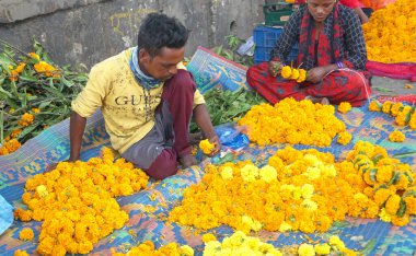 INDIA - 15 Ekim 2021: Hintli çiçek satıcıları ürünlerini gündüz vakti sokak çiçeği pazarında sunuyorlar