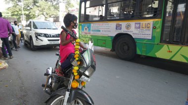 INDIA - 15 Ekim 2021: Meşgul caddede süslü motosiklet kullanan Hintli genç çocuk