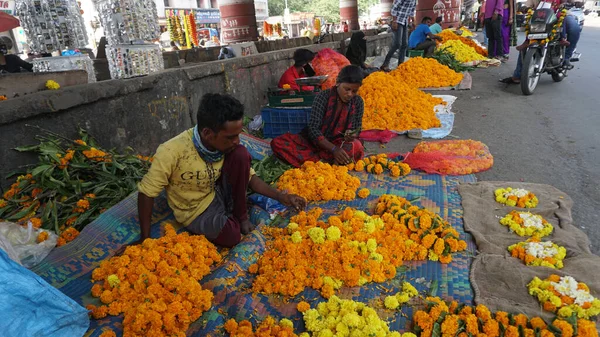 INDIA - 15 Ekim 2021: Hintli çiçek satıcıları ürünlerini gündüz vakti sokak çiçeği pazarında sunuyorlar