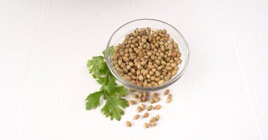 Kuru kişniş tohumları ve yeşil taze demet kişniş yaprakları, Asya mutfağında ünlü baharatlar..