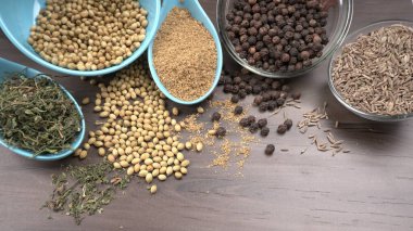 Ahşap masada kişniş tohumları, Hint baharatları ve otları