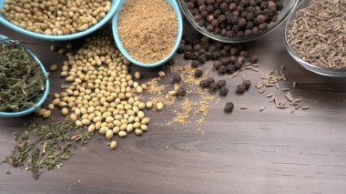 Ahşap masada kişniş tohumları, Hint baharatları ve otları
