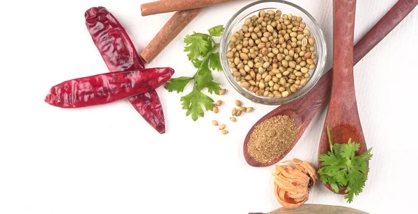 Kuru kişniş tohumları ile küçük bambu kaşıkları ve yeşil demet kişniş yaprakları, Asya mutfağında ünlü baharatlar..