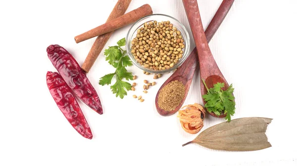 Kuru kişniş tohumları ile küçük bambu kaşıkları ve yeşil demet kişniş yaprakları, Asya mutfağında ünlü baharatlar..