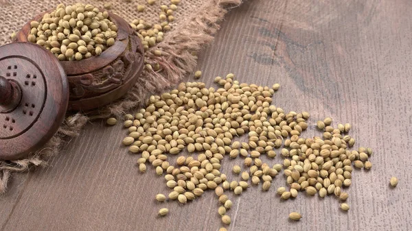 Ahşap masada kişniş tohumları, Hint baharatları ve otları