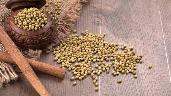 Ahşap masada kişniş tohumları, Hint baharatları ve otları