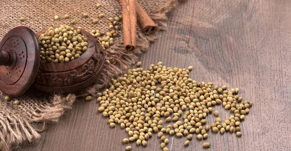 Ahşap masada kişniş tohumları, Hint baharatları ve otları