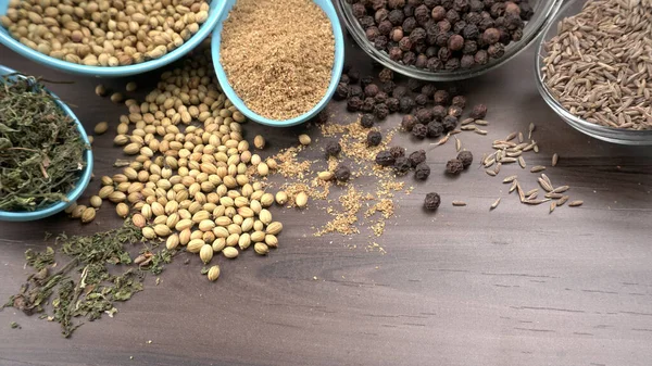 Ahşap masada kişniş tohumları, Hint baharatları ve otları