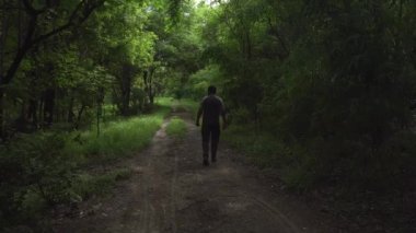 INDIA - 18 Temmuz 2021: Yaz parkında yürüyen genç Hintli adam 