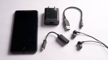 OTG tipi C ve siyah cep telefonu, kulaklık ve dış ses kartı beyaz arkaplanda izole edilmiş. .