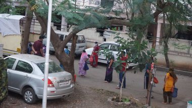 INDIA - 1 Mayıs 2020: Hintliler gündüz vakti arabaları ve yeşil ağaçlarıyla caddelerde hareket ediyorlar 