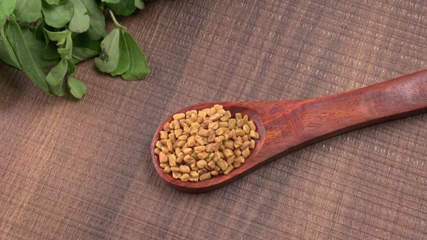 Kuru kişniş tohumları ile küçük bambu kaşığı ve yeşil taze demet kişniş yaprakları, Asya mutfağında ünlü baharatlar..