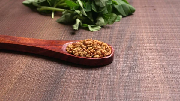 Kuru kişniş tohumları ile küçük bambu kaşığı ve yeşil taze demet kişniş yaprakları, Asya mutfağında ünlü baharatlar..