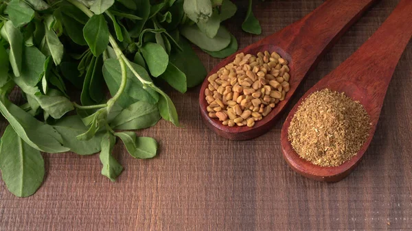 Kuru kişniş tohumları ile küçük bambu kaşıkları ve yeşil demet kişniş yaprakları, Asya mutfağında ünlü baharatlar..