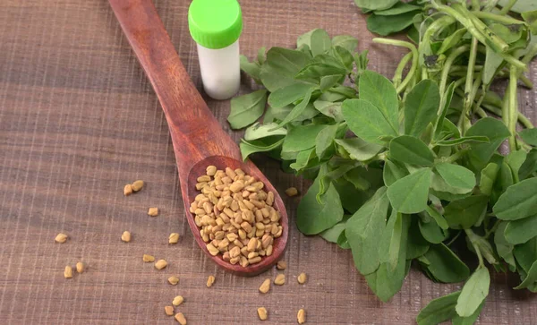 Kuru kişniş tohumları ile küçük bambu kaşığı ve yeşil taze demet kişniş yaprakları, Asya mutfağında ünlü baharatlar..