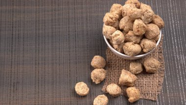 Ahşap arka planda çiğ soya parçaları. Sağlıklı, besleyici soya fasulyesi eti. Vejetaryen gıda konsepti.