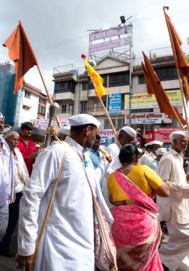 PUNE, MAHARASHTRA, INDIA - 24 HAZİRAN 2022: Pandharpur savaş alayı yolcuları Vitthala tapınağına doğru dans ederek dini şarkılar söyleyerek yürürken.