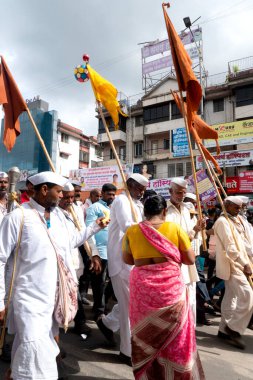 PUNE, MAHARASHTRA, INDIA - 24 HAZİRAN 2022: Pandharpur savaş alayı yolcuları Vitthala tapınağına doğru dans ederek dini şarkılar söyleyerek yürürken.
