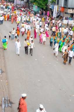 PUNE, MAHARASHTRA, INDIA - 24 HAZİRAN 2022: Pandharpur savaş alayı yolcuları Vitthala tapınağına doğru dans ederek dini şarkılar söyleyerek yürürken.