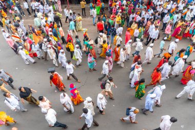 PUNE, MAHARASHTRA, INDIA - 24 HAZİRAN 2022: Pandharpur savaş alayı yolcuları Vitthala tapınağına doğru dans ederek dini şarkılar söyleyerek yürürken.
