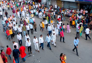 PUNE, MAHARASHTRA, INDIA - 24 HAZİRAN 2022: Pandharpur savaş alayı yolcuları Vitthala tapınağına doğru dans ederek dini şarkılar söyleyerek yürürken.