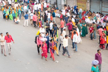 PUNE, MAHARASHTRA, INDIA - 24 HAZİRAN 2022: Pandharpur savaş alayı yolcuları Vitthala tapınağına doğru dans ederek dini şarkılar söyleyerek yürürken.