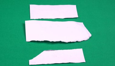 Beyaz çizgili, not defteri, yeşil arkaplana yapıştırılmış mesaj veya metin için not kağıdı.