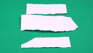 Beyaz çizgili, not defteri, yeşil arkaplana yapıştırılmış mesaj veya metin için not kağıdı.