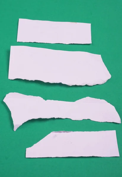 白色撕破条纹 笔记本 文字或信息的便笺贴在绿色背景上 — 图库照片