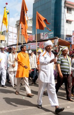 PUNE, MAHARASHTRA, INDIA - 24 HAZİRAN 2022: Pandharpur savaş alayı yolcuları Vitthala tapınağına doğru dans ederek dini şarkılar söyleyerek yürürken.