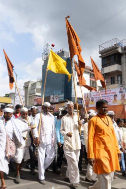PUNE, MAHARASHTRA, INDIA - 24 HAZİRAN 2022: Pandharpur savaş alayı yolcuları Vitthala tapınağına doğru dans ederek dini şarkılar söyleyerek yürürken.