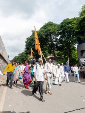 PUNE, MAHARASHTRA, INDIA - 24 HAZİRAN 2022: Pandharpur savaş alayı yolcuları Vitthala tapınağına doğru dans ederek dini şarkılar söyleyerek yürürken.