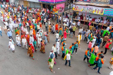 PUNE, MAHARASHTRA, INDIA - 24 HAZİRAN 2022: Pandharpur savaş alayı yolcuları Vitthala tapınağına doğru dans ederek dini şarkılar söyleyerek yürürken.