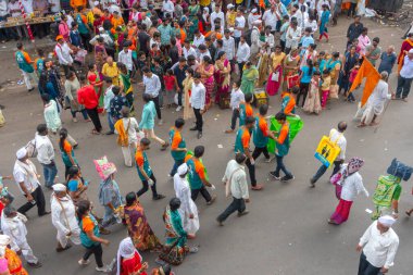 PUNE, MAHARASHTRA, INDIA - 24 HAZİRAN 2022: Pandharpur savaş alayı yolcuları Vitthala tapınağına doğru dans ederek dini şarkılar söyleyerek yürürken.