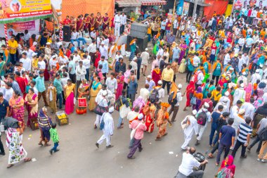 PUNE, MAHARASHTRA, INDIA - 24 HAZİRAN 2022: Pandharpur savaş alayı yolcuları Vitthala tapınağına doğru dans ederek dini şarkılar söyleyerek yürürken.