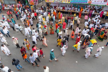 PUNE, MAHARASHTRA, INDIA - 24 HAZİRAN 2022: Pandharpur savaş alayı yolcuları Vitthala tapınağına doğru dans ederek dini şarkılar söyleyerek yürürken.