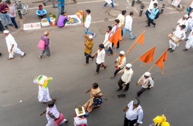 PUNE, MAHARASHTRA, INDIA - 24 HAZİRAN 2022: Pandharpur savaş alayı yolcuları Vitthala tapınağına doğru dans ederek dini şarkılar söyleyerek yürürken.