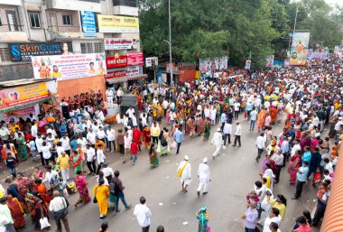 PUNE, MAHARASHTRA, INDIA - 24 HAZİRAN 2022: Pandharpur savaş alayı yolcuları Vitthala tapınağına doğru dans ederek dini şarkılar söyleyerek yürürken.