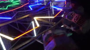 Geceleri renkli neon ışıklı dönme dolap.