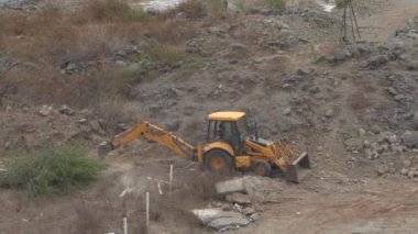 INDIA - 24 HAZİRAN, 2022: inşaat tarafında çalışan traktörler üzerinde çalışan işçi. Hava görünümü.