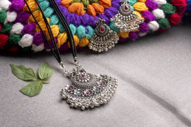 Indian traditional antique or retro style pendant with earrings on colorful knitted background
