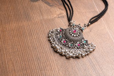 Indian traditional antique or retro style pendant on wooden background 