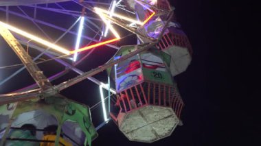 Geceleri renkli neon ışıklı dönme dolap.